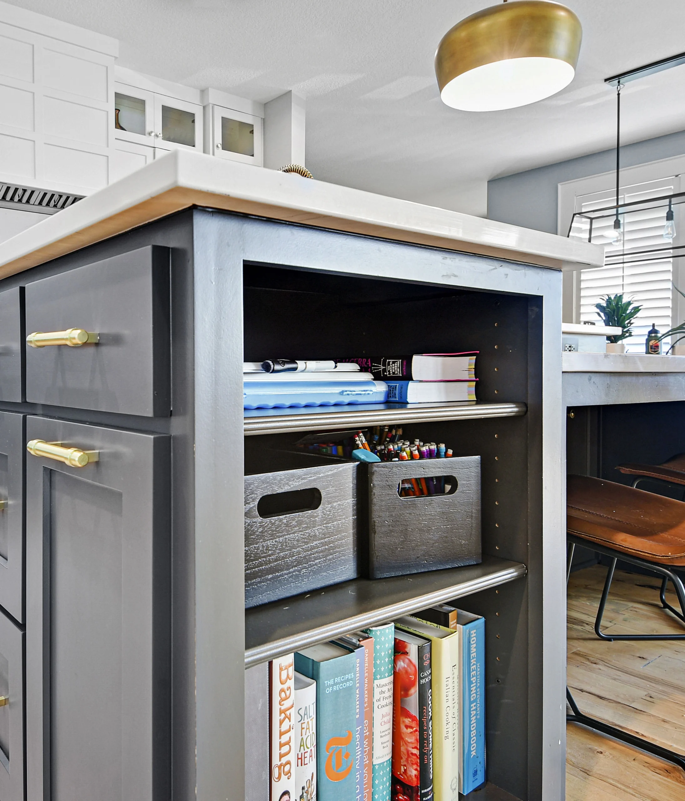 Whole home remodeling featuring a custom kitchen island with built in shelving and modern cabinetry
