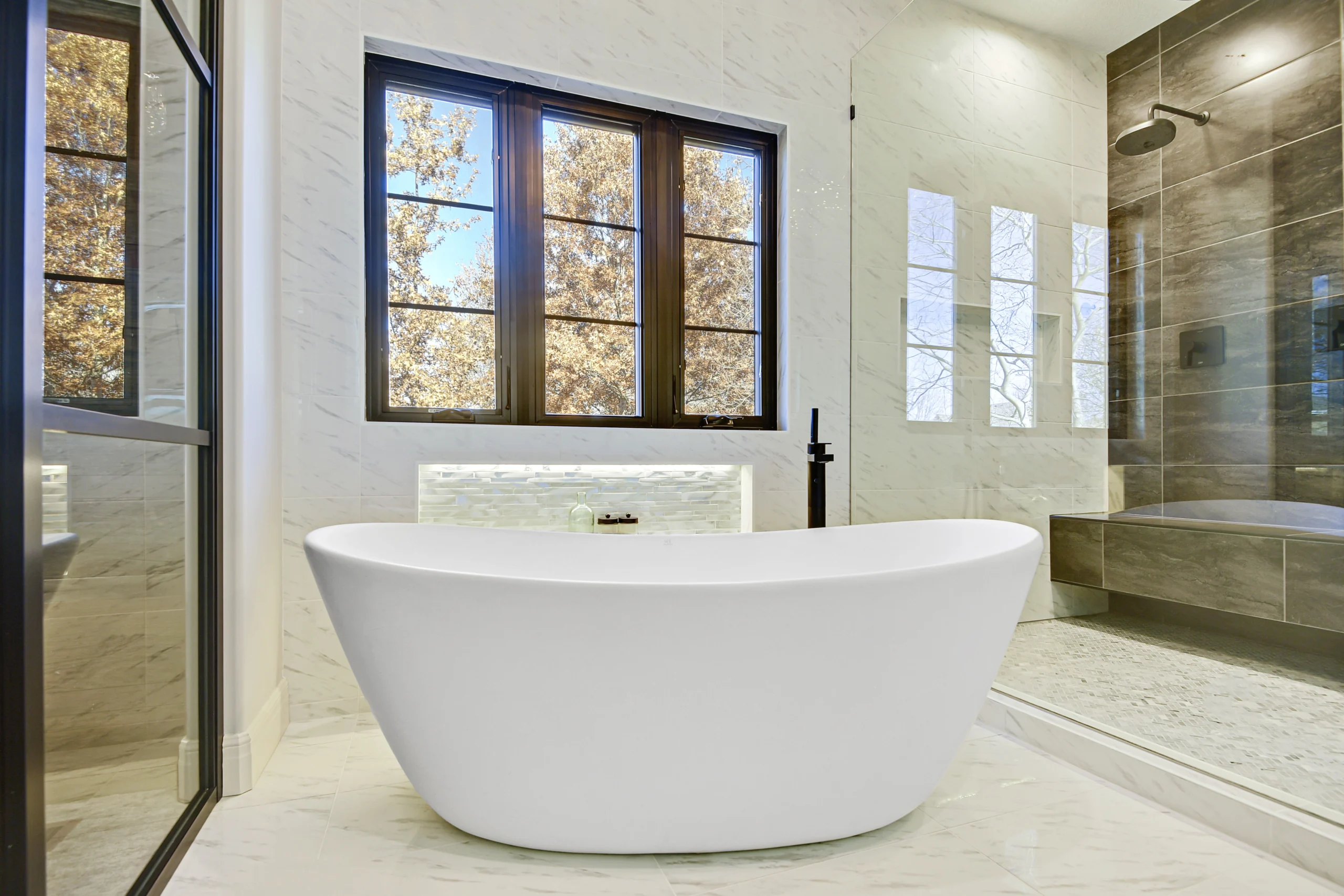 Luxury bathroom remodel with freestanding soaking tub and walk-in glass shower